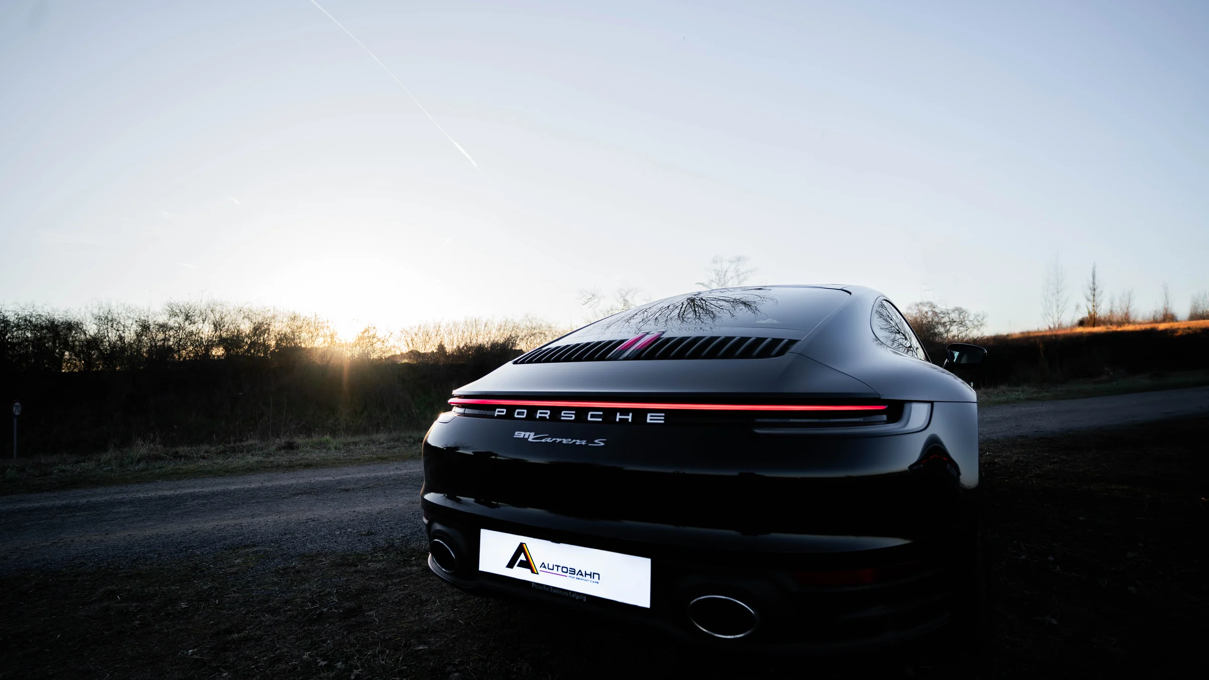 Black Porsche 911 photographed at sunset during Autobahn operations in Germany